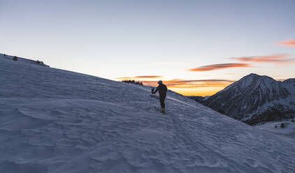 Männlicher Sportler beim Bergsteigen in den Pyrenäen bei Sonnenaufgang - JAQF00266