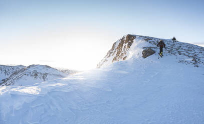 Männlicher Skifahrer auf dem Gipfel eines verschneiten Berges - JAQF00276