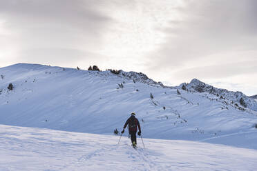 Male skier climbing at Pyrenees during sunrise - JAQF00283