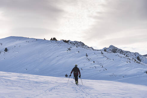 Männlicher Skifahrer beim Klettern in den Pyrenäen bei Sonnenaufgang - JAQF00283