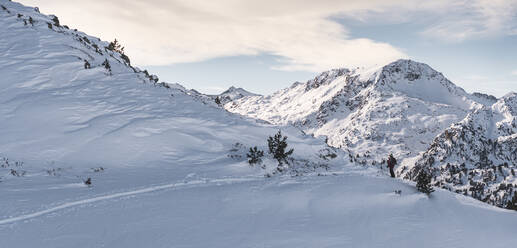 Älterer männlicher Skifahrer auf der Skipiste der Pyrenäen gegen den bewölkten Himmel - JAQF00286