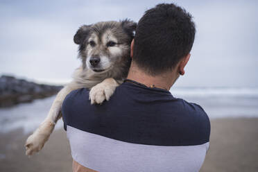 Mann mit Hund am Strand gegen den Himmel - SNF01175