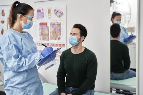 Female doctor examining male patient before taking medical test stock photo