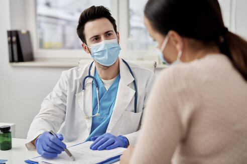 Male doctor talking with patient in clinic - ABIF01357