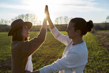 Couple dancing on green land during sunset - VEGF03865