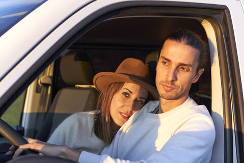 Woman embracing boyfriend while sitting in car stock photo