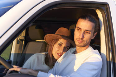 Frau umarmt ihren Freund, während sie im Auto sitzt - VEGF03873