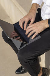 Male entrepreneur using digital tablet while sitting on steps - BOYF01827