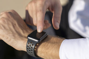 Close-up of businessman using smart watch outdoors - BOYF01835