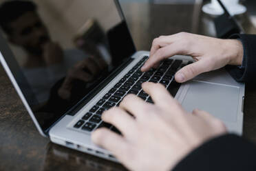 Mittlerer erwachsener Mann mit Laptop auf dem Tisch - EGAF01707