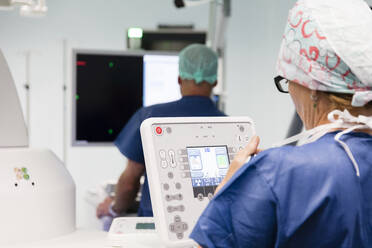 Ein Techniker bedient ein medizinisches Bildgebungsgerät im Operationssaal - CAVF92792