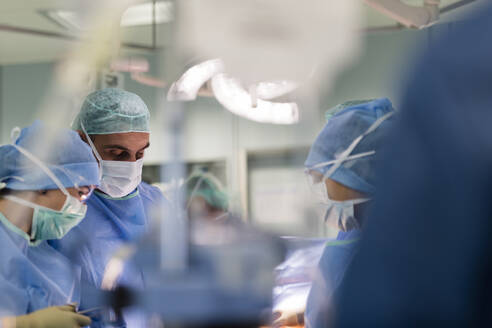 Ein Chirurg im Operationssaal beobachtet einen Patienten - CAVF92884