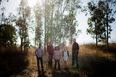 Fünfköpfige Familie im Feld stehend, für die Kamera posierend - CAVF92926
