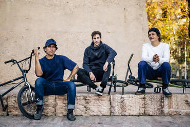 Drei Männer posieren mit ihren BMX-Fahrrädern in der Stadt Madrid Spanien - CAVF92968