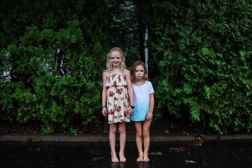 Porträt von zwei im Regen stehenden Mädchen - CAVF93103