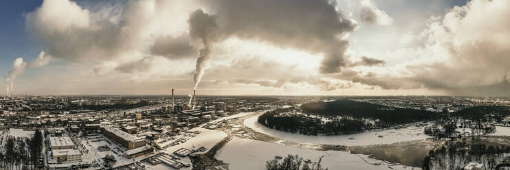Germany, Berlin, Smoking power plant chimney towering over frozen Spree river - MJRF00357