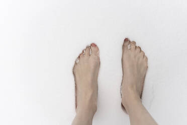 Barefoot woman standing in snow - CHPF00752