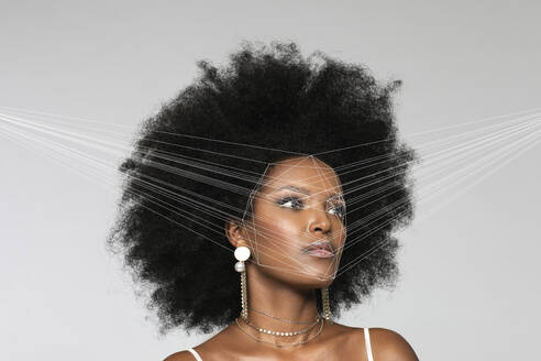 Afro woman with facial recognition laser beam while looking away against white background - EIF00368