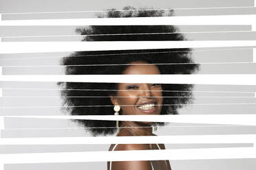 Lächelnde Afro-Frau mit digitalen Streifen im Gesicht vor weißem Hintergrund - EIF00371
