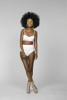 Skinny female model wearing bikini standing against white