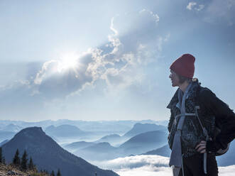 Female tourist standing on Heuberg mountain against cloudy sky during sunny day - HAMF00815