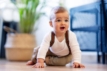 Süßes Baby spielt auf dem Boden sitzend zu Hause - PGF00440