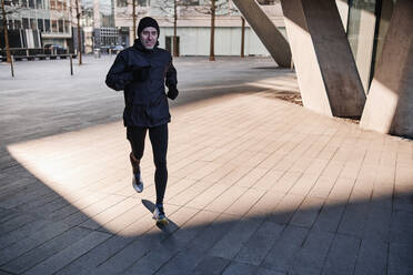 Älterer Mann joggt unter einer Brücke an einem sonnigen Tag - ASGF00013