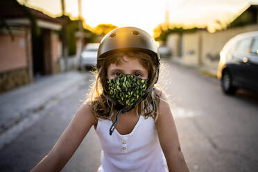 Mädchen mit Schutzmaske und Helm bei Sonnenuntergang - AMPF00020