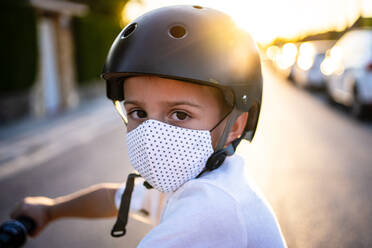 Junge mit Schutzmaske und Helm bei Sonnenuntergang - AMPF00022