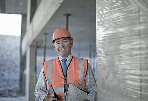 Älterer männlicher Architekt auf einer Baustelle - AJOF01030