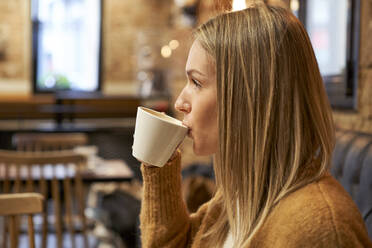 Junge Frau trinkt Kaffee in einem Cafe - VEGF03876