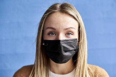 Young woman with protective face mask against wall - VEGF03902