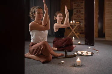 Female friends meditating with Eagle arms together - CAVF93212