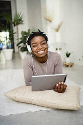 Smiling female entrepreneur using digital tablet at home - RCPF00679