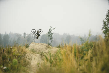 Mountain biker flipping a jump in Bellingham Washington - CAVF93288