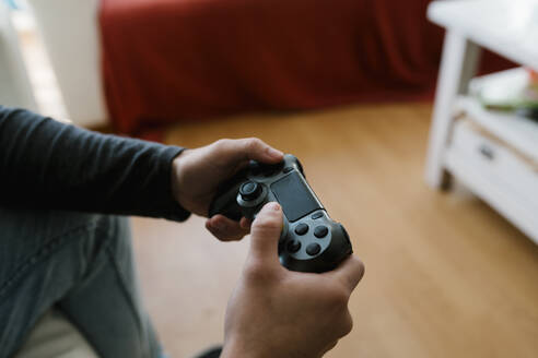 Mann mit Spielcontroller spielt Videospiel zu Hause - EGAF01749