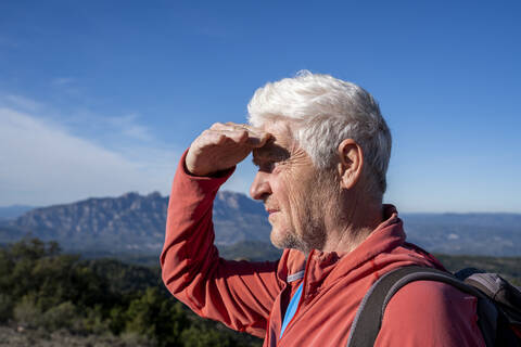 Senior man admiring view while standing against sky at Sant Llorenc del Munt i l'Obac, Catalonia, Spain stock photo