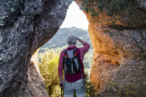 Backpacker admiring view while standing in natural park of Sant Llorenc del Munt i l'Obac at Catalonia, Spain stock photo