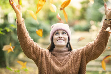 Smiling woman in knit hat enjoying autumn day - AKLF00050