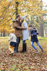 Paar macht Romantik im Stehen mit Kindern, die im Wald herumlaufen - WPEF04162