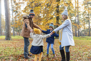 Kinder halten die Hand der Eltern beim Spielen im Wald - WPEF04179