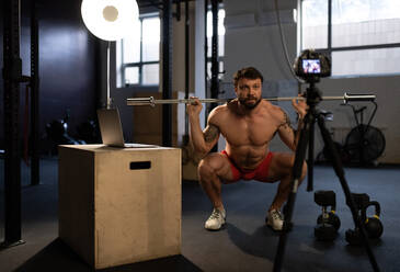 Sportsman doing squats with bar in front of camera - CAVF93334