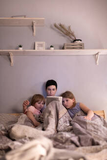 Mutter und Töchter sehen sich vor dem Schlafengehen einen Film an - CAVF93355