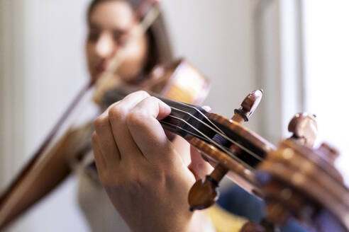 Musician girl playing a viola, focus on the strings. - CAVF93380