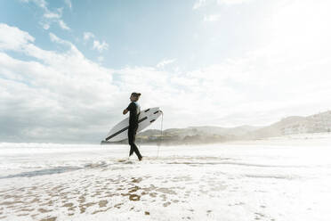 Surfer beim Eintauchen ins Wasser im Baskenland, Spanien, Bilbao - CAVF93402