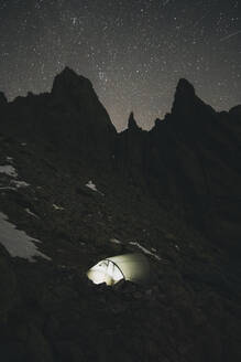 Beleuchtetes Zelt vor Granitspitzen und Sternenhimmel in einer Winternacht, Gredos, Avila, Spanien - CAVF93434