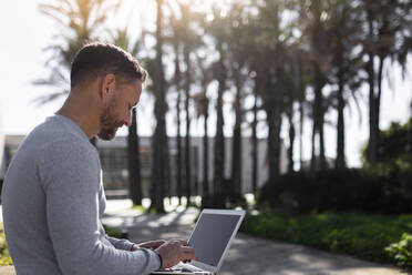 Male entrepreneur using laptop at park - JPTF00665