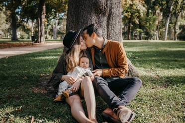 Loving young parents with cute infant child enjoying summer weekend together in green park - ADSF20946