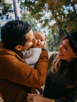 Loving young parents with cute infant child enjoying summer weekend together in green park - ADSF20947