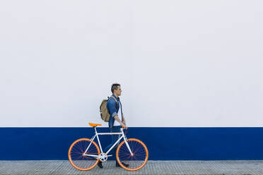 Mann mit Fahrrad auf dem Gehweg - XLGF01195